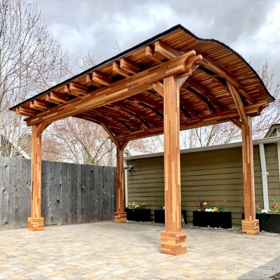 Backyard Pavilion Kits (Options: 13'-6" L x 10' Arc W, Mosaic Redwood, 4-Post Anchor Kit for High-Wind, No Ceiling Fan Base, No Privacy Panels, Electrical Wiring Trim Kit for 1 Post, 9 ft Post Height, Transparent Premium Sealant). Photo Courtesy of E. Baechler of Portland, Oregon.